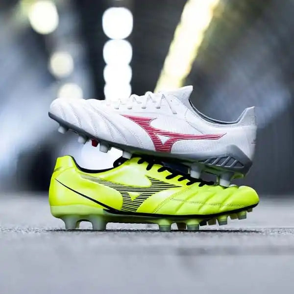 Image of Deux crampons de soccer Mizuno empilés, l'un blanc avec des accents rouges et l'autre jaune néon avec des accents noirs.